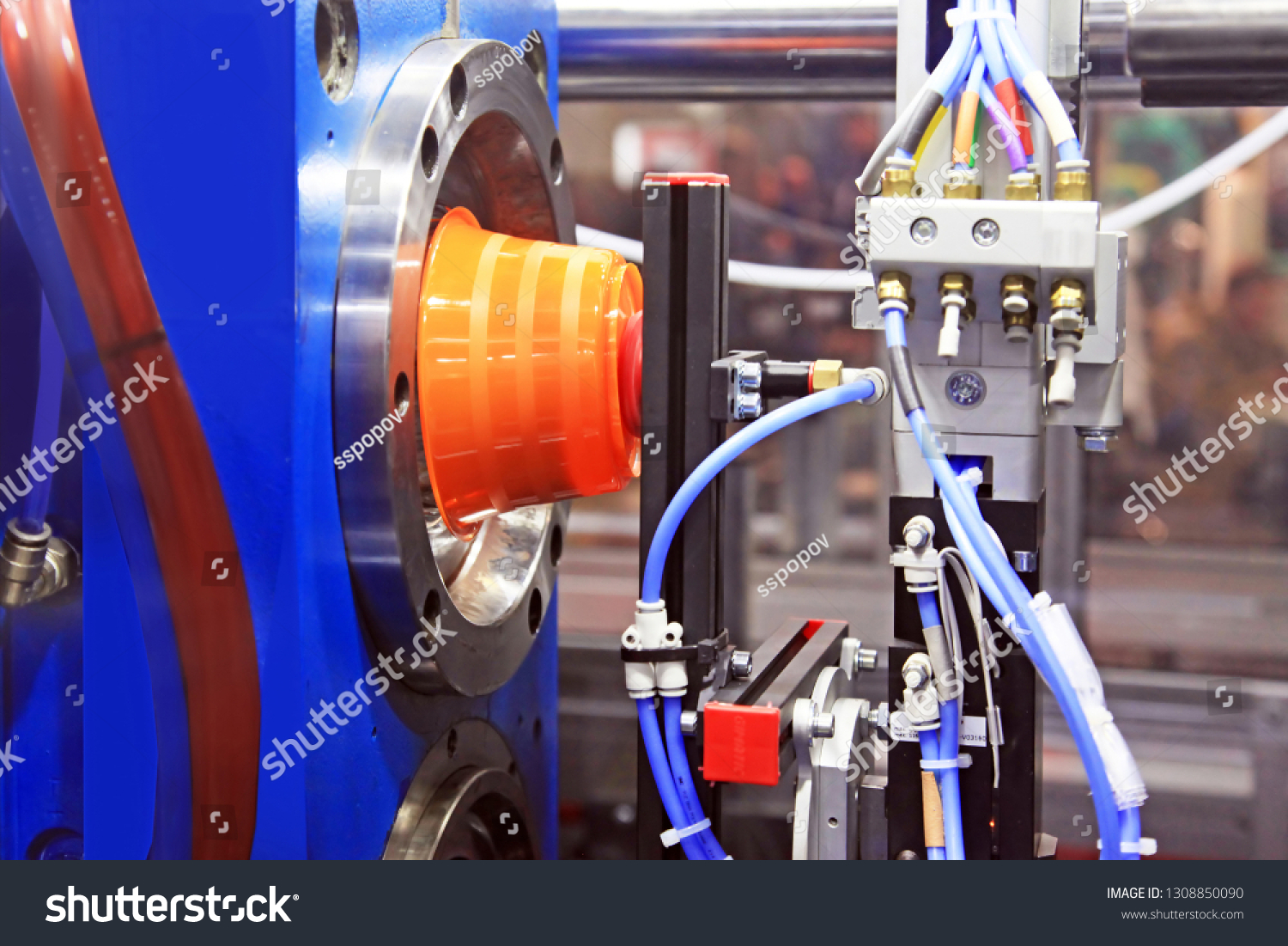 stock-photo-the-finished-part-is-removed-from-the-injection-molding-machine-vacuum-robot-1308850090